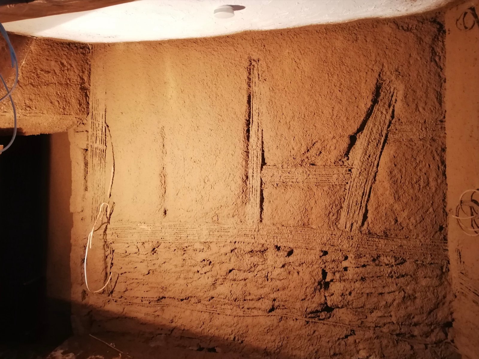 Frischer Lehmunterputz auf Innenwand mit sichtbaren Strohrohren, Fachwerkhaus Ahrtal