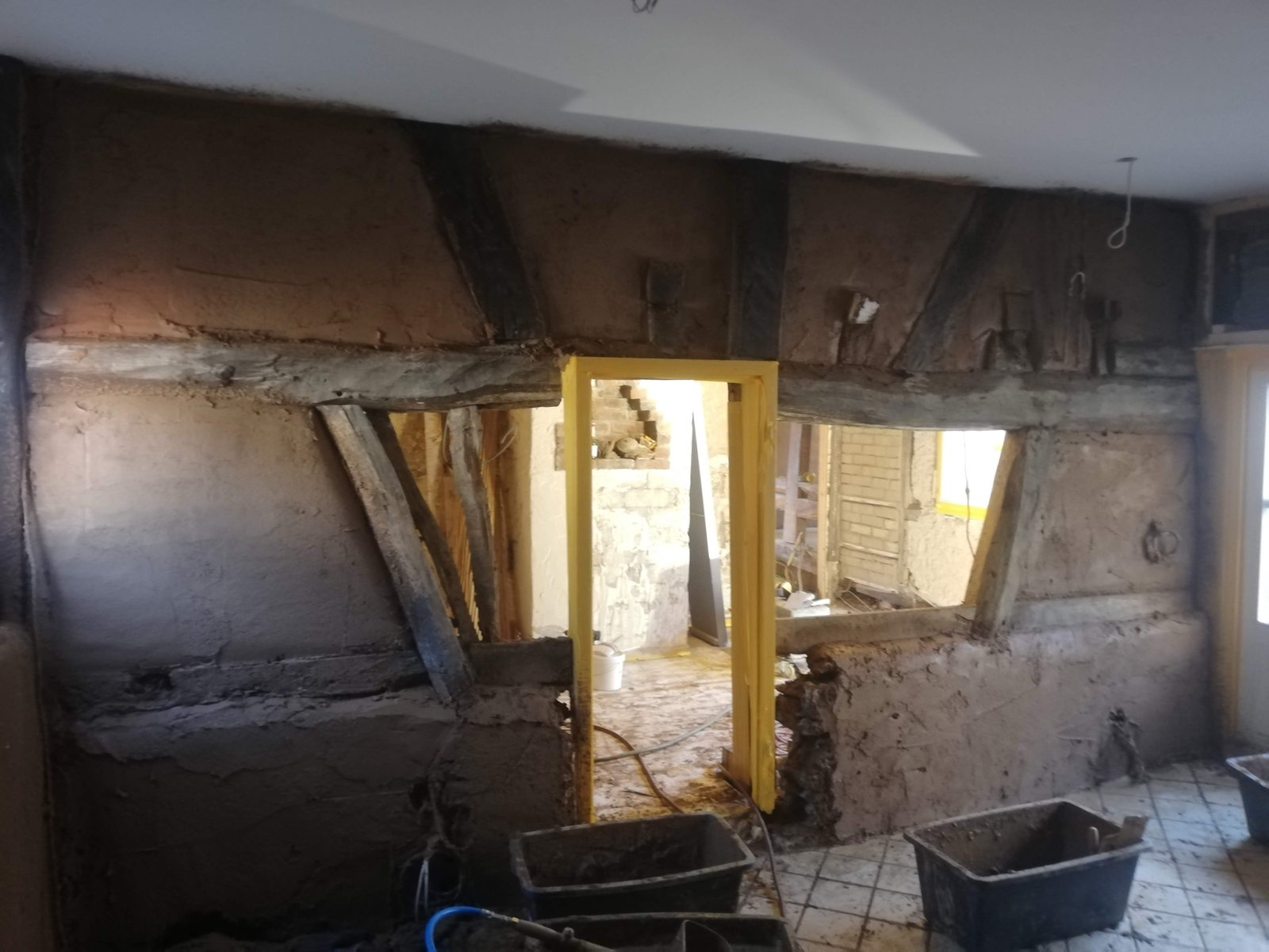 Freigelegtes Fachwerkgefach mit Lehmputzuntergrund und Durchbruch zur nächsten Etage