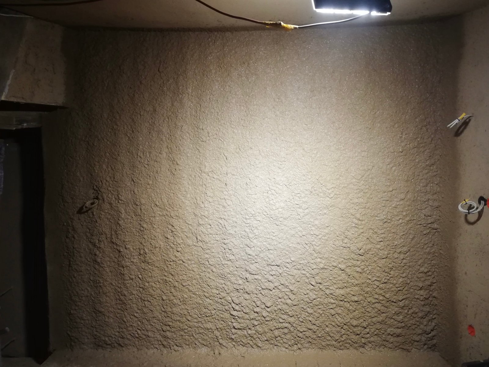 Lehmunterputz auf großer Wandfläche, gleichmäßig aufgetragen, Rohbauphase