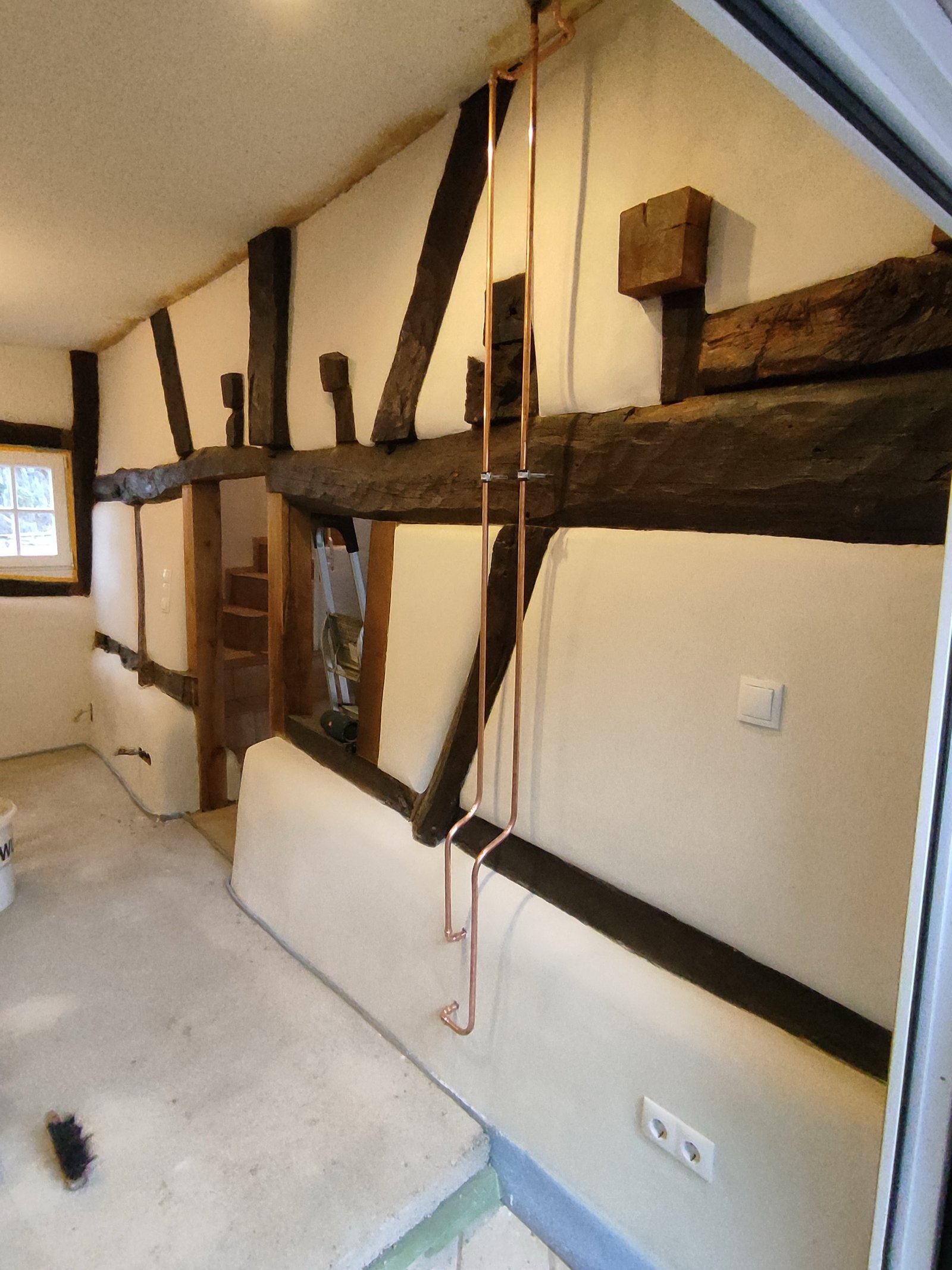Fachwerkinnenwand mit frischem Kalkputz und Kupfer-Leitungsrohren, Sanierungsphase