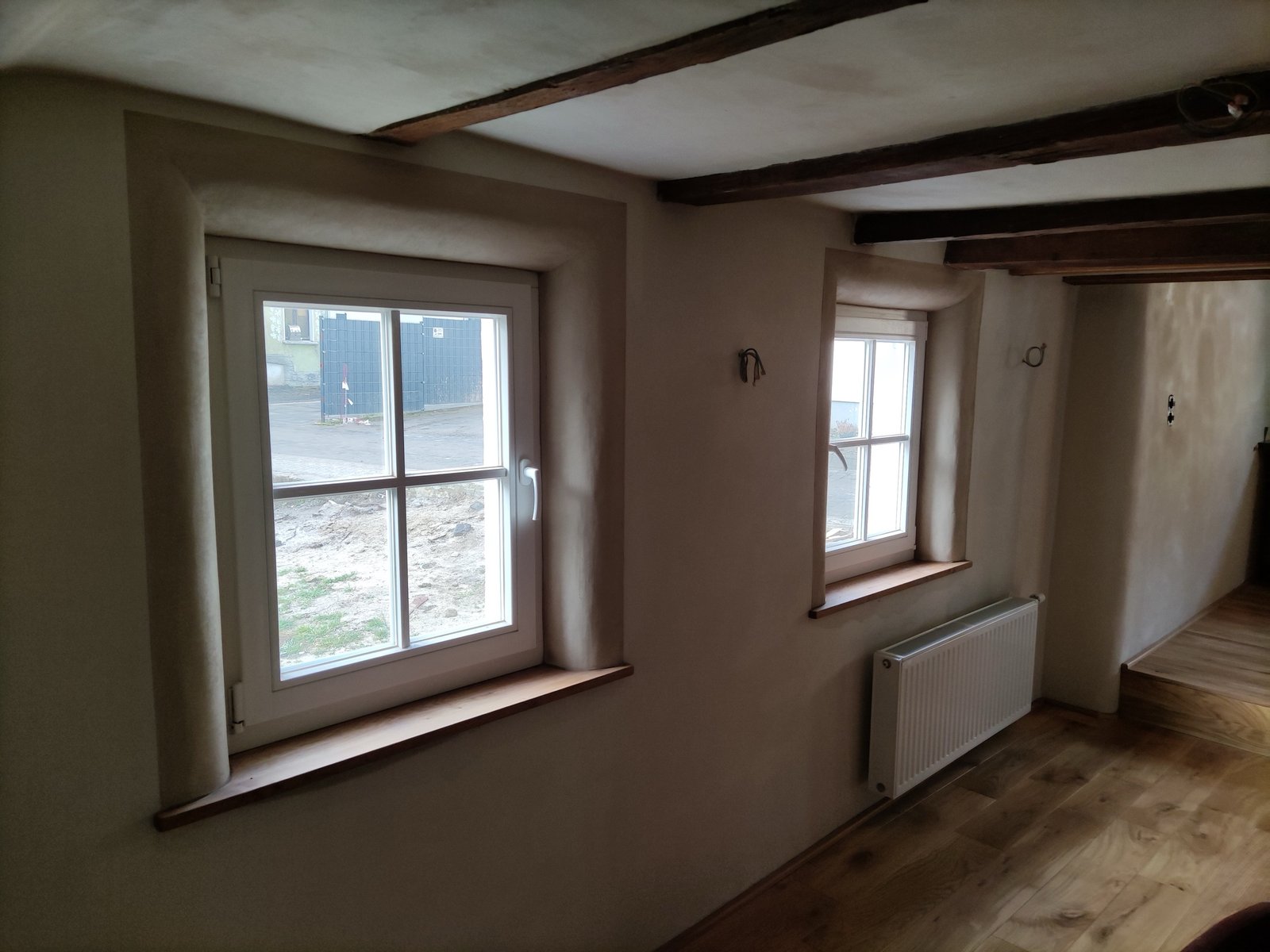 Fachwerkhaus im Ahrtal nach Sanierung: weiße Putzflächen, Bruchsteinsockel, Kochfeld