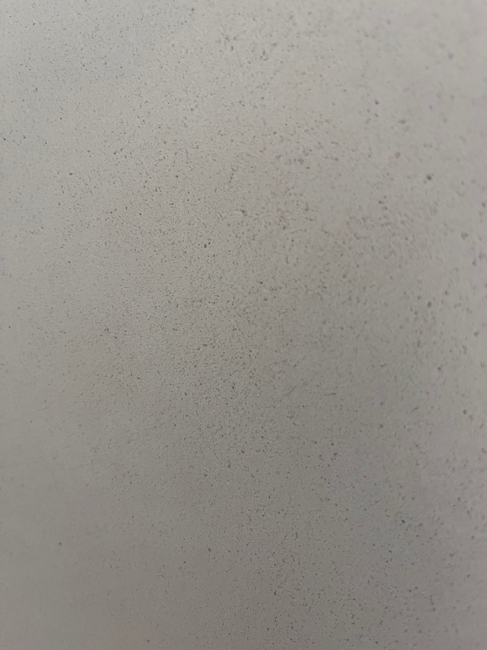 Kalkputz-Oberfläche mit mineralischer Körnung, weißlich, gleichmäßige Poren sichtbar