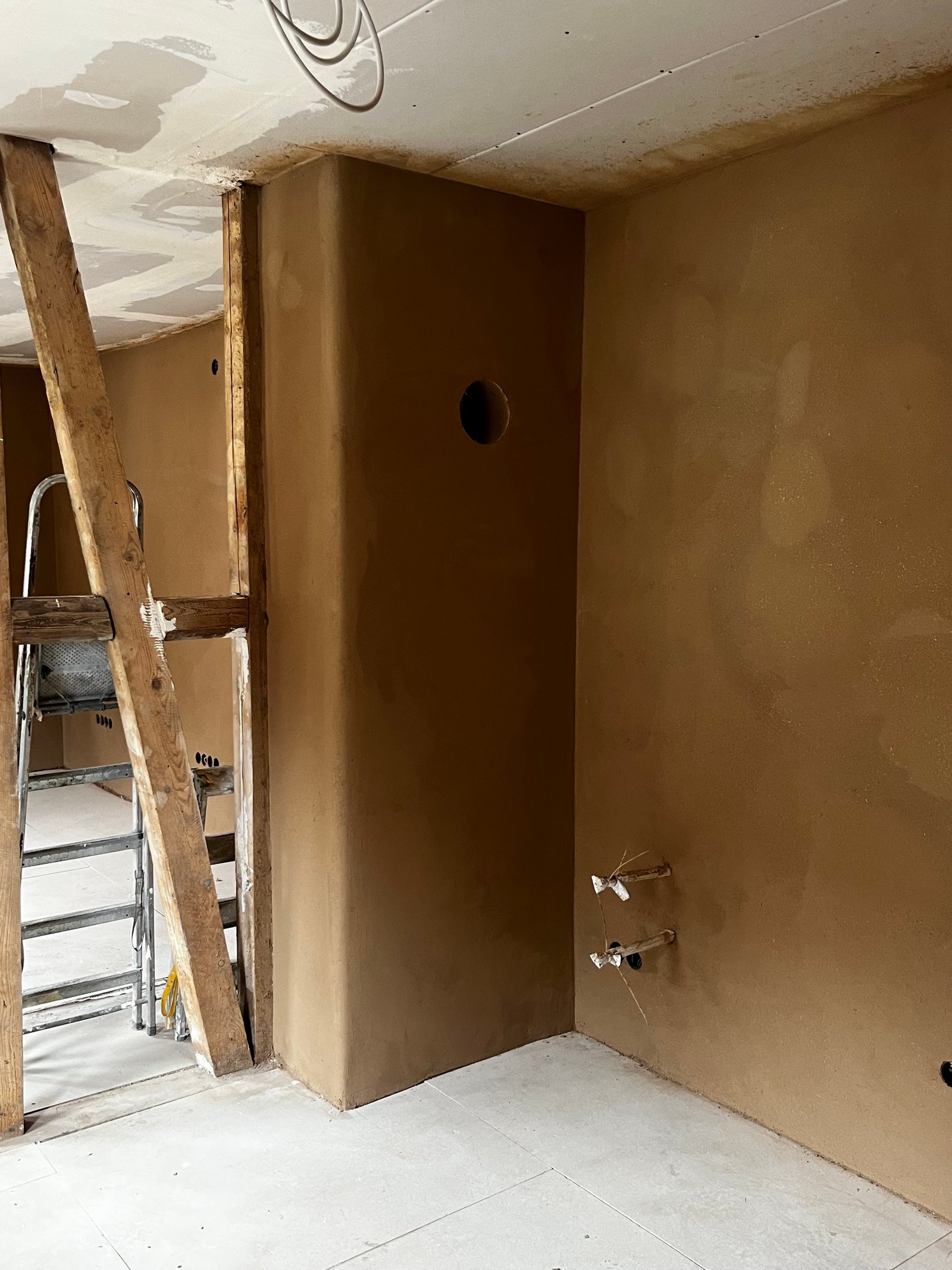 Lehmputz Dachgeschoss fertig: schräge Wandflächen gleichmäßig verputzt, Dachfenster