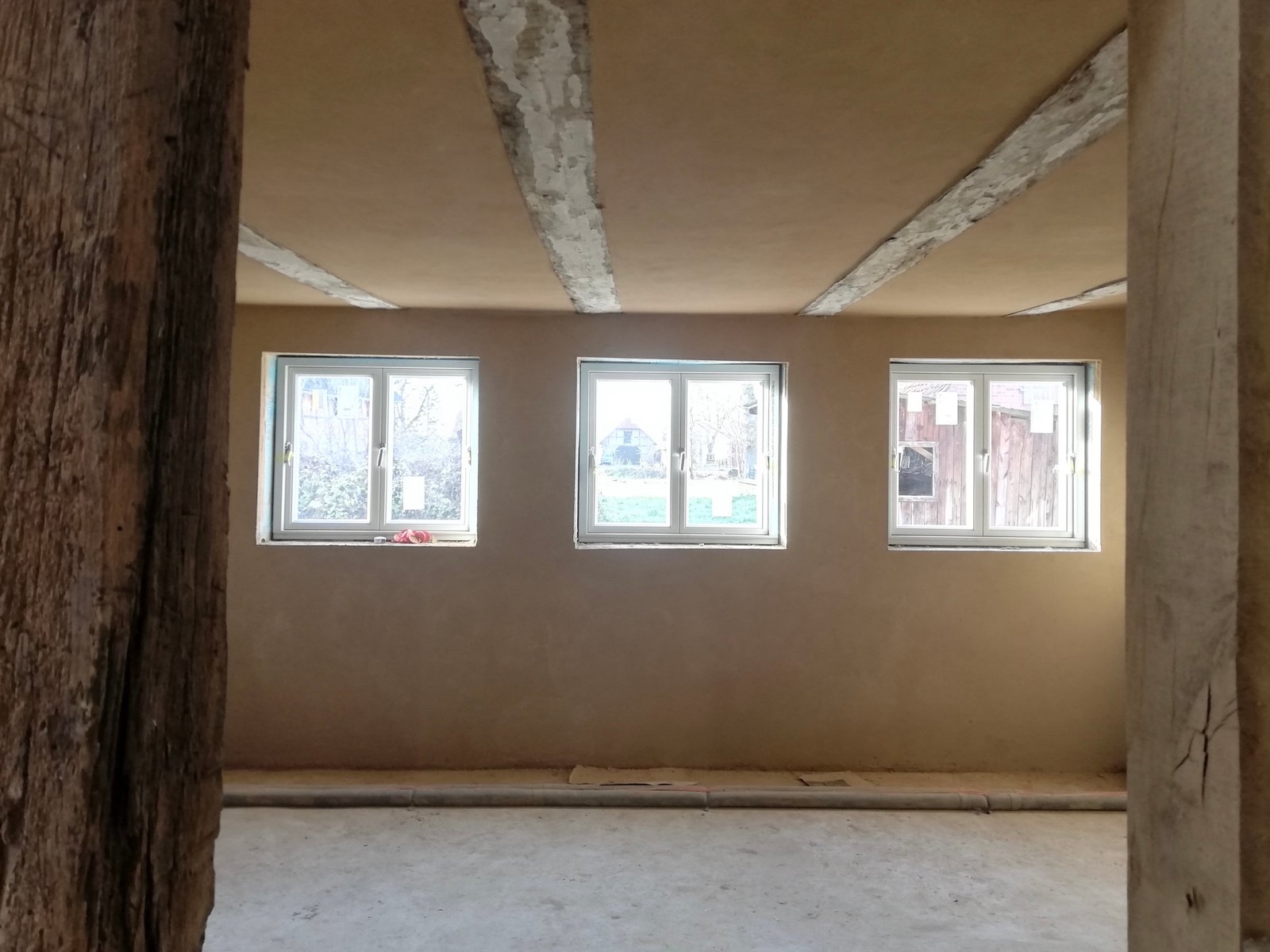 Lehmputz-Wandfläche mit Holzbalken, Fachwerkhaus Niedersachsen, Putzauftrag abgeschlossen