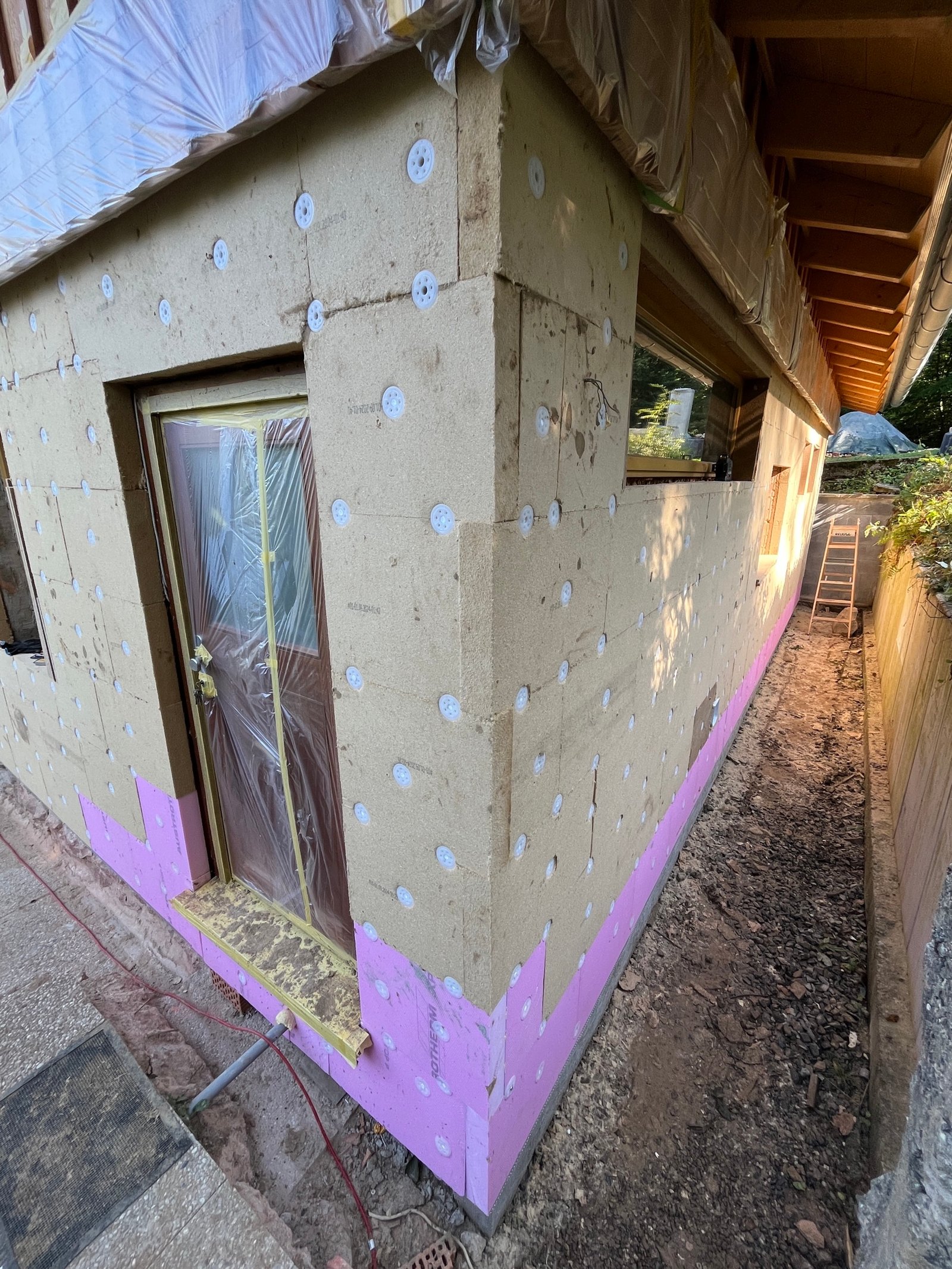 Holzfaserdämmplatten auf Fassade montiert: zwei Kellerfenster, Befestigungsscheiben