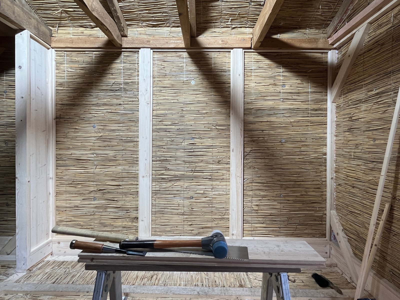 Gartenhaus-Innenraum vor Sanierung: verwitterte Holzverkleidung, alte Küchenzeile