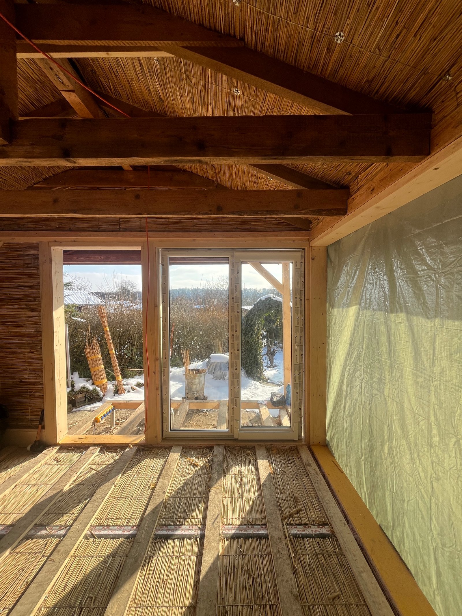Gartenhaus-Außenansicht: Zedernholz-Fassade mit fertigem Fenster und Putzübergang