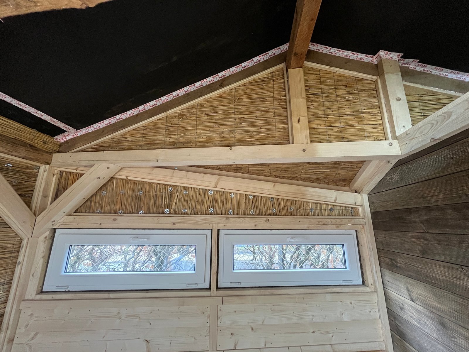 Gartenhaus-Innenraum fertig: Holzdielenboden, Lehmputzwände, Schilfrohrdecke