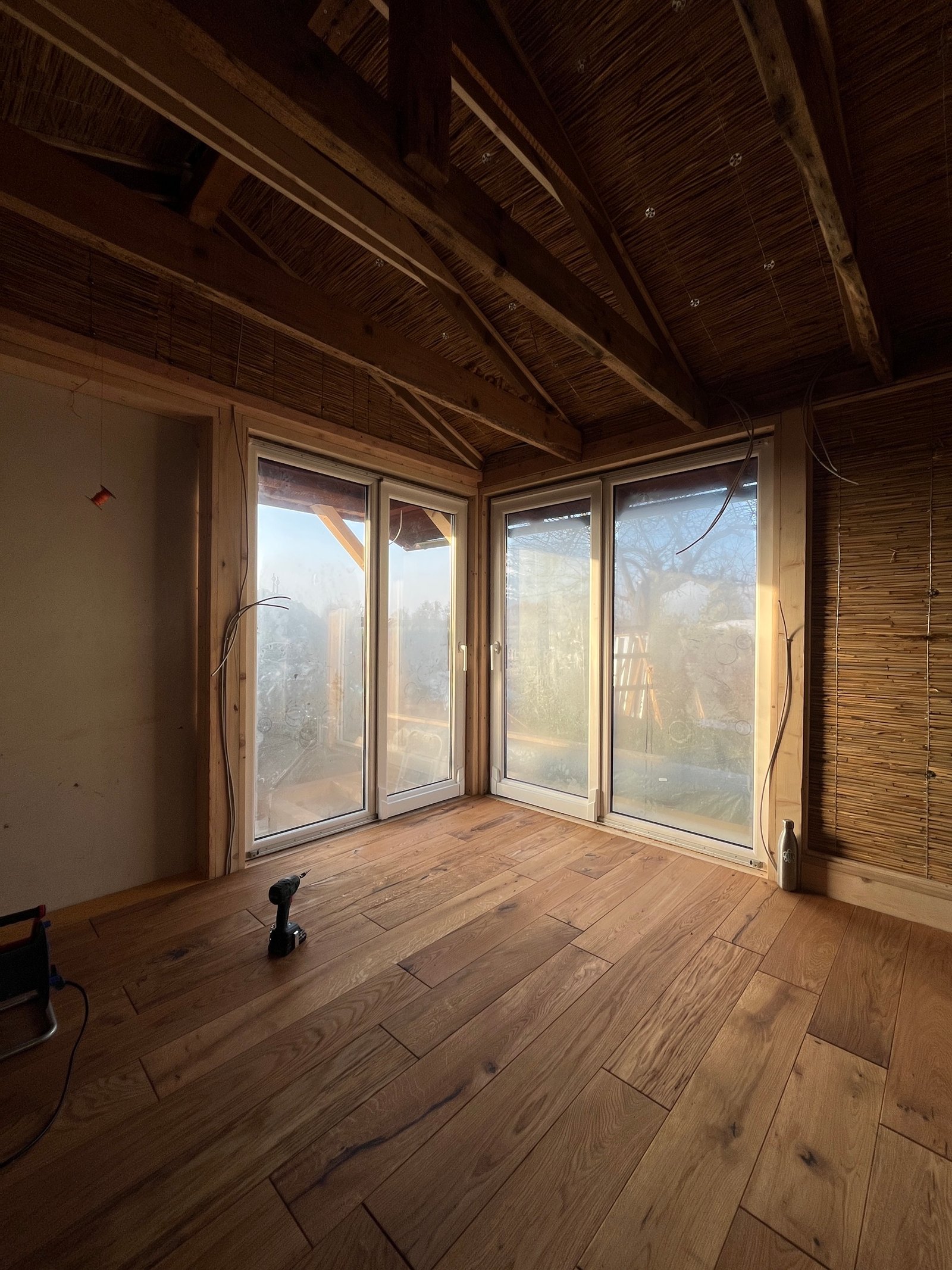 Gartenhaus fertiggestellt: Blick auf Klarglasfenster, Holzfassade, Schilfrohrdecke