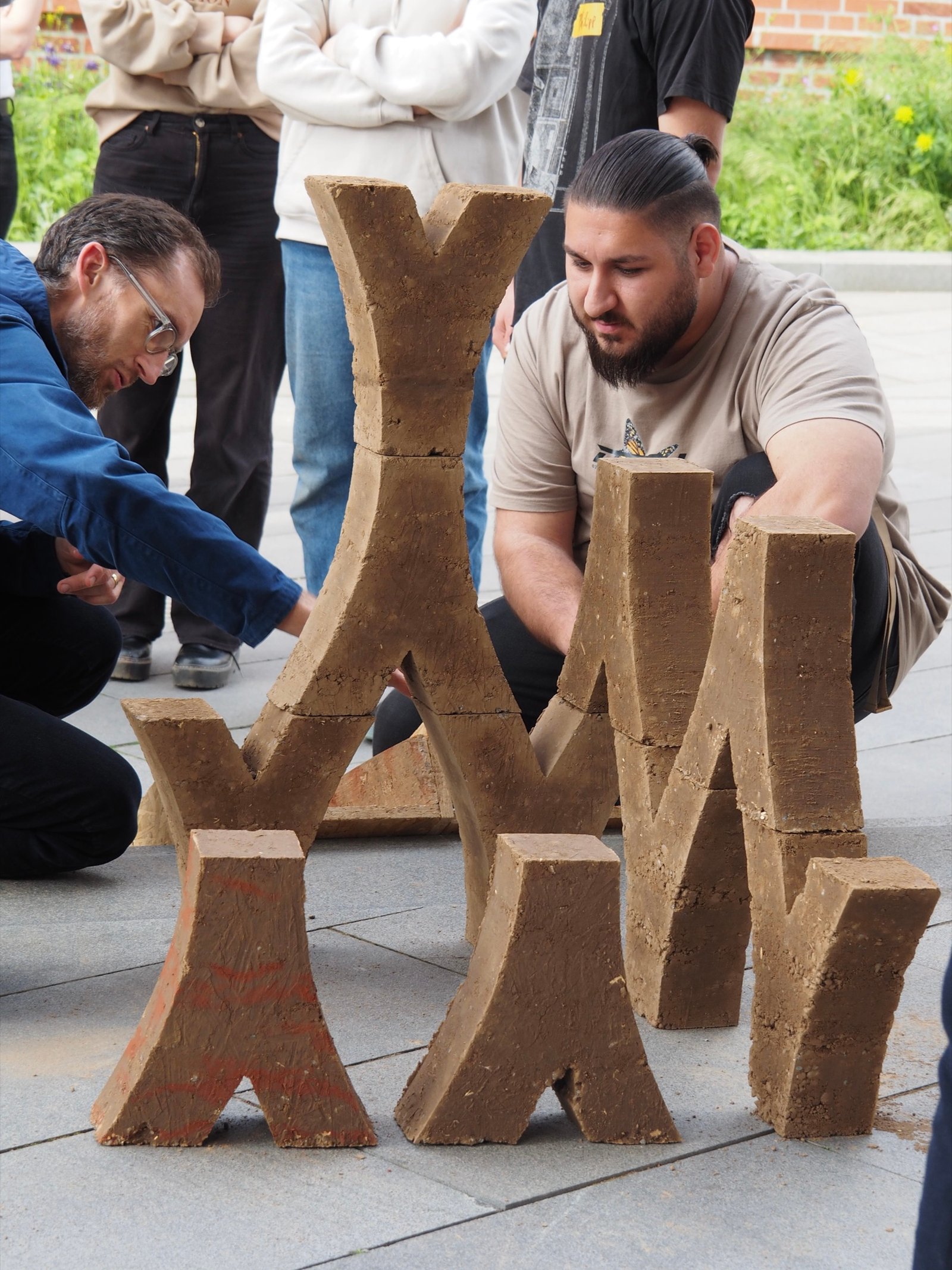 Lehm-Workshop: Studierende bauen Y-förmige Skulpturen aus gestampftem Lehm