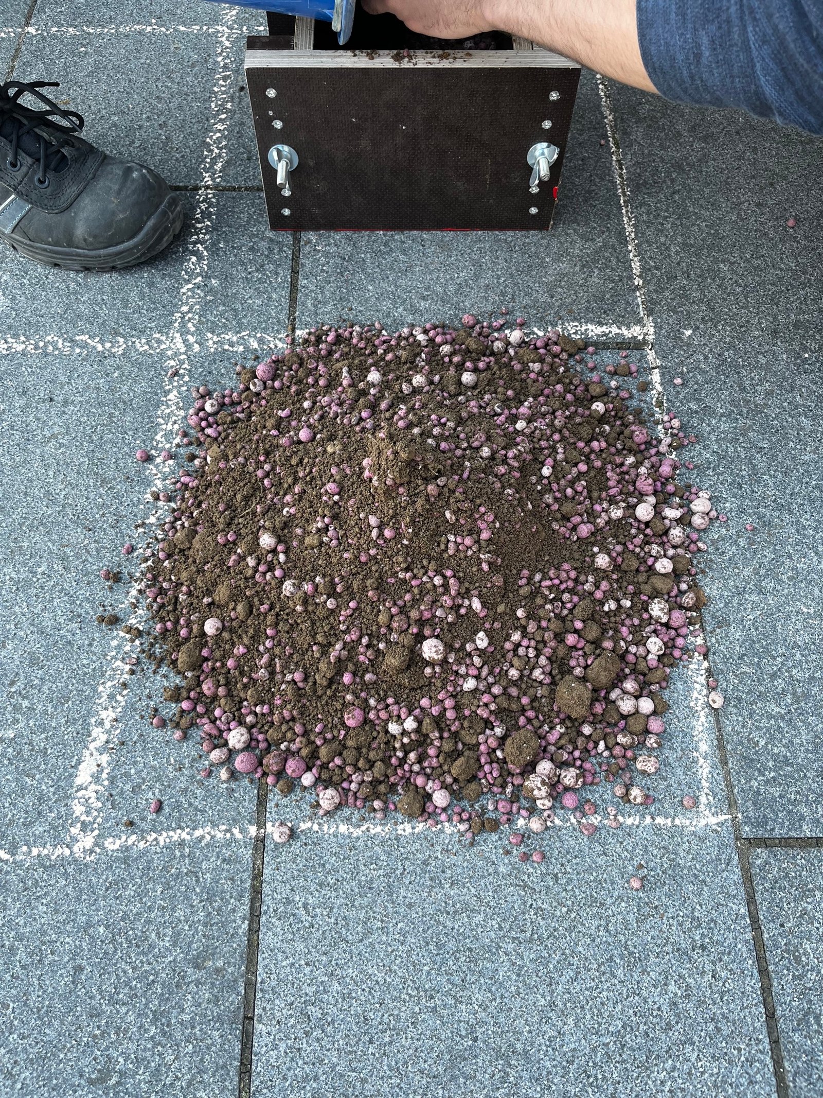 Lehmproben-Übersicht: Kiesbeimischungen in neun Feldern auf Pflasterstein