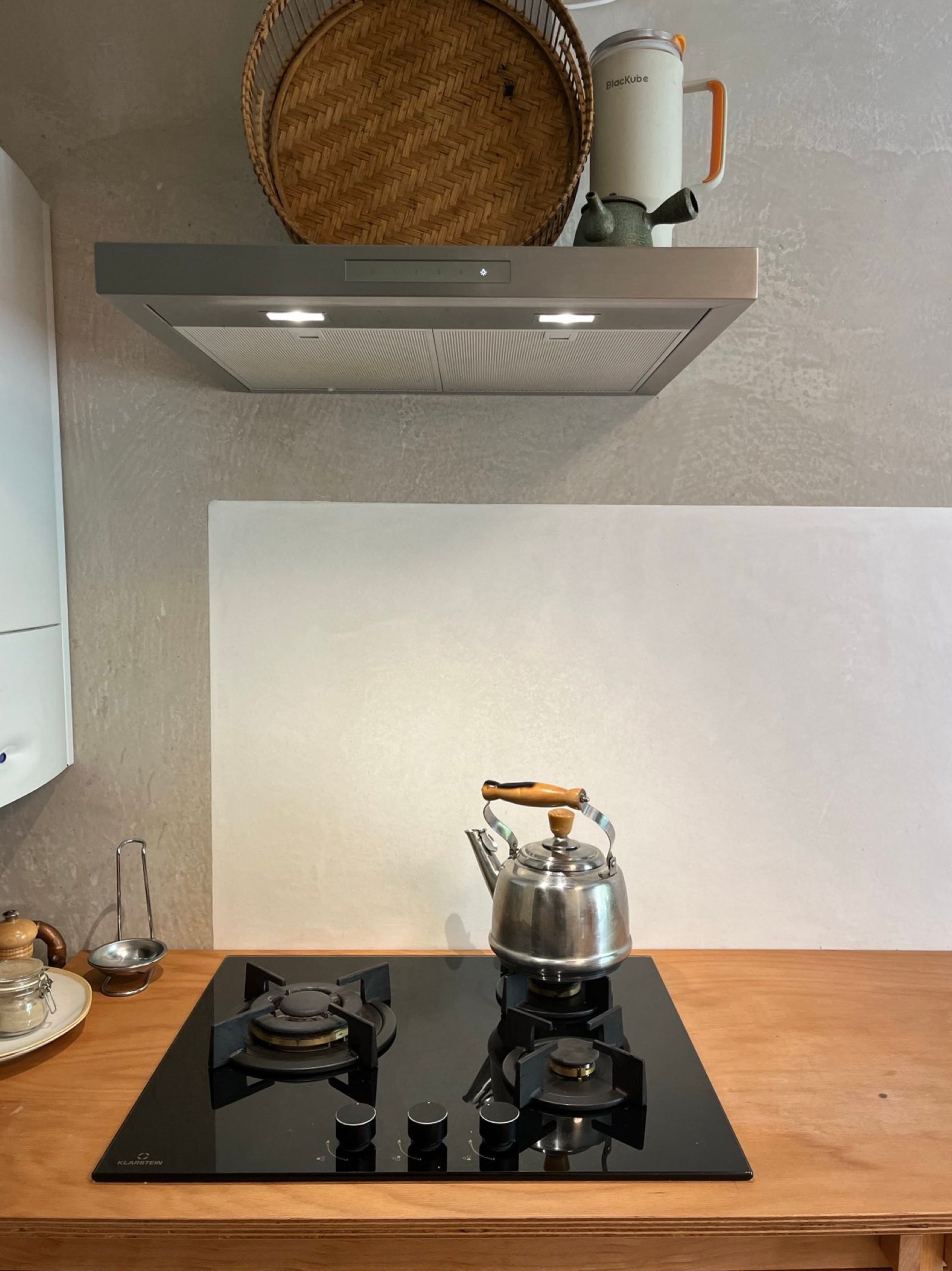 Kalkputz-Küchenrückwand hinter Induktionskochfeld: feiner Mineralputz, Glätte