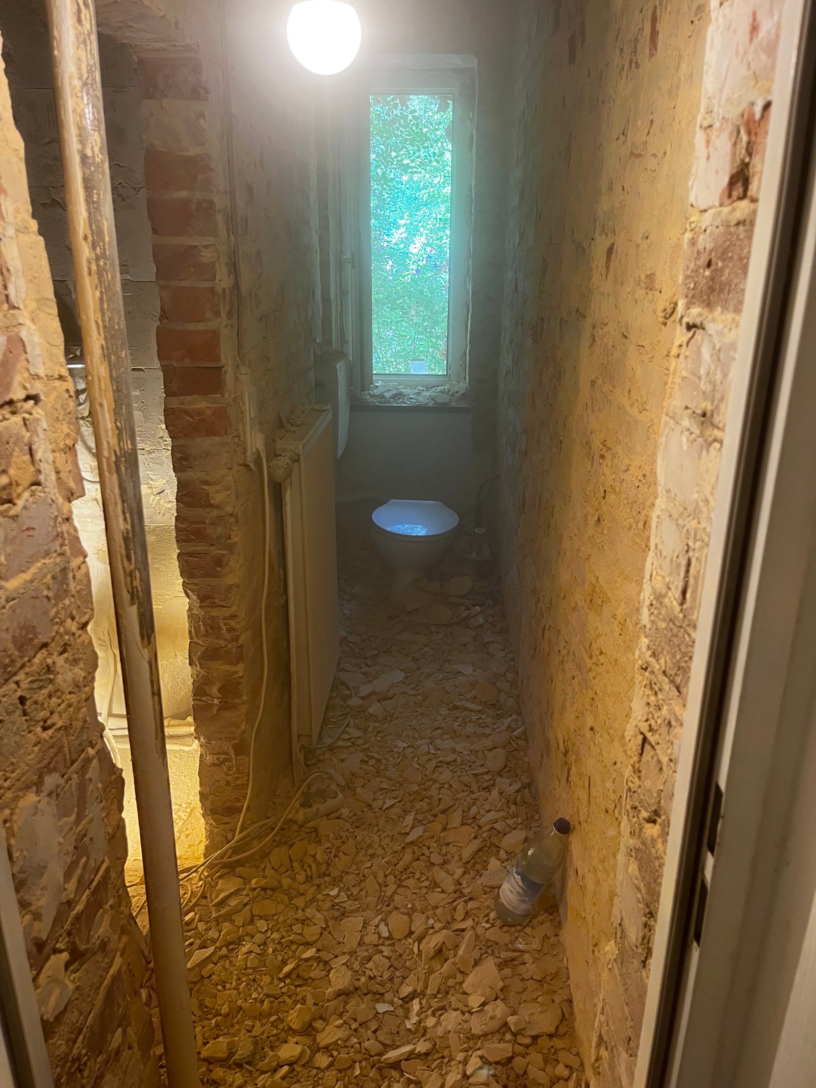 Kalkputz auf Innenwand: Rohputzphase mit Leitungsrohren, gleichmäßige Putzlage