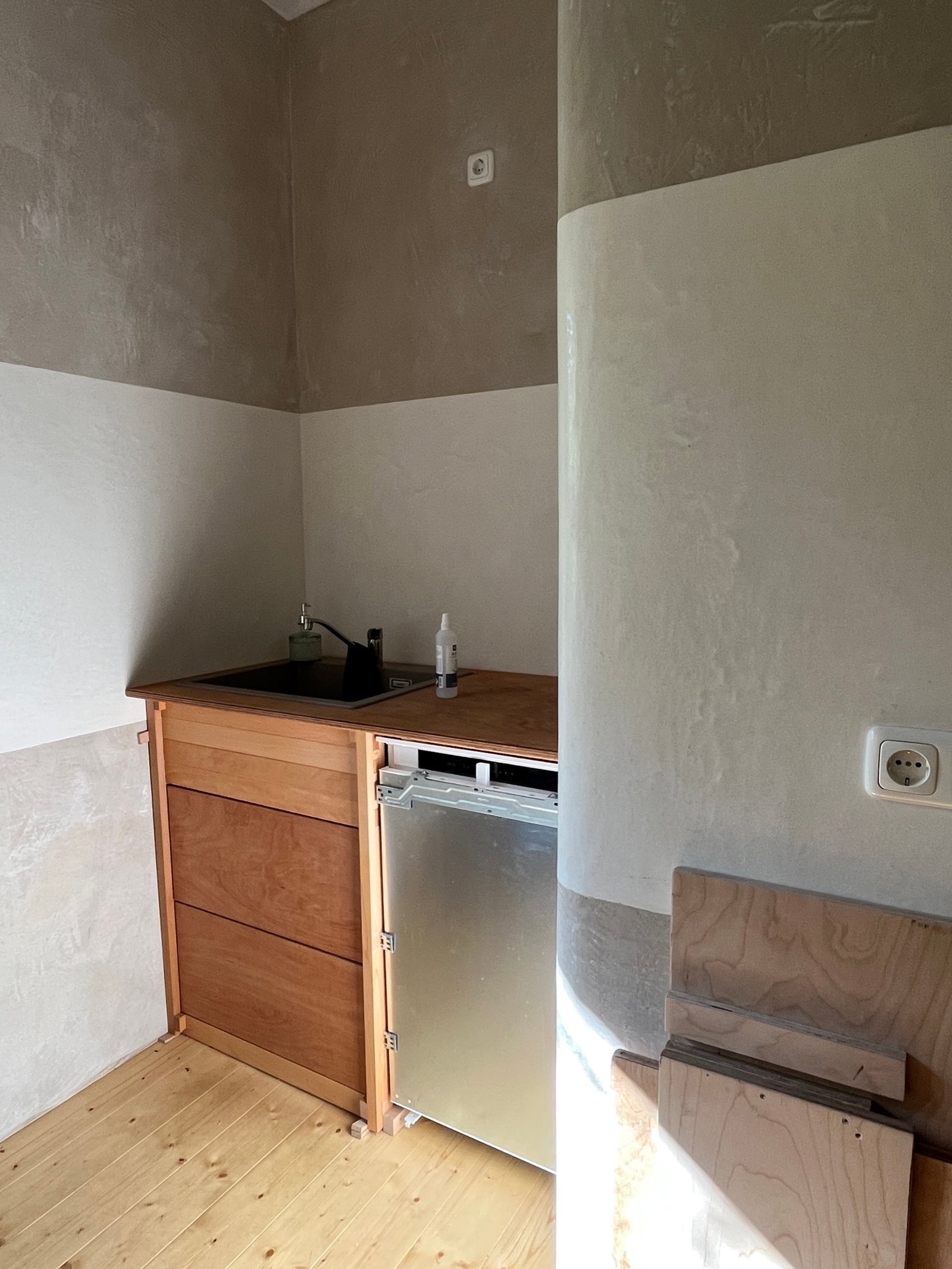 Sanierter Raum nach Schimmelbehandlung: Kalkputzwände fertig, Kaminbereich verputzt