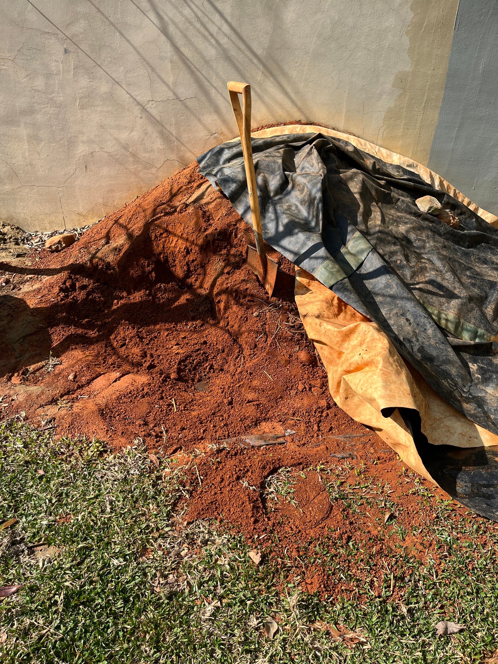 Roter Lehmboden auf Plane mit Schaufel, Lehmaufbereitung für Stampflehmwand Taiwan