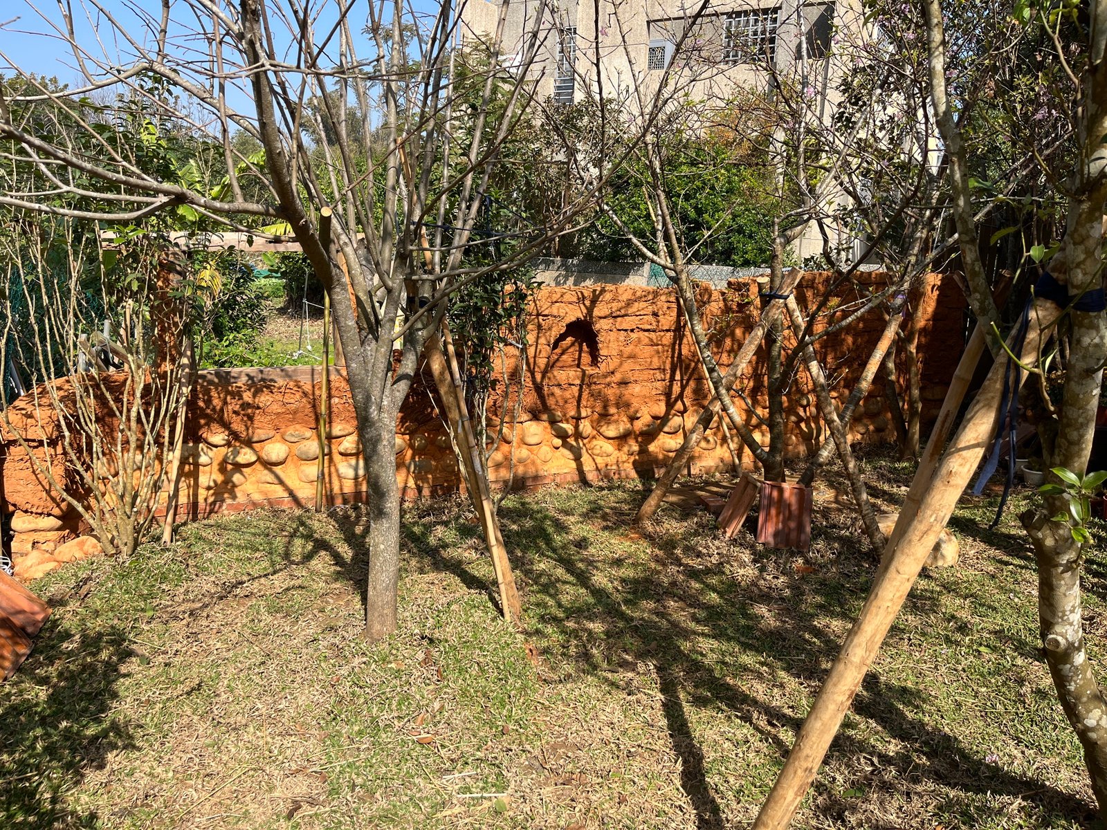 Lehmziegelmauer im Garten Taiwan, roter Ton mit Strohrissen, Bestand historisch