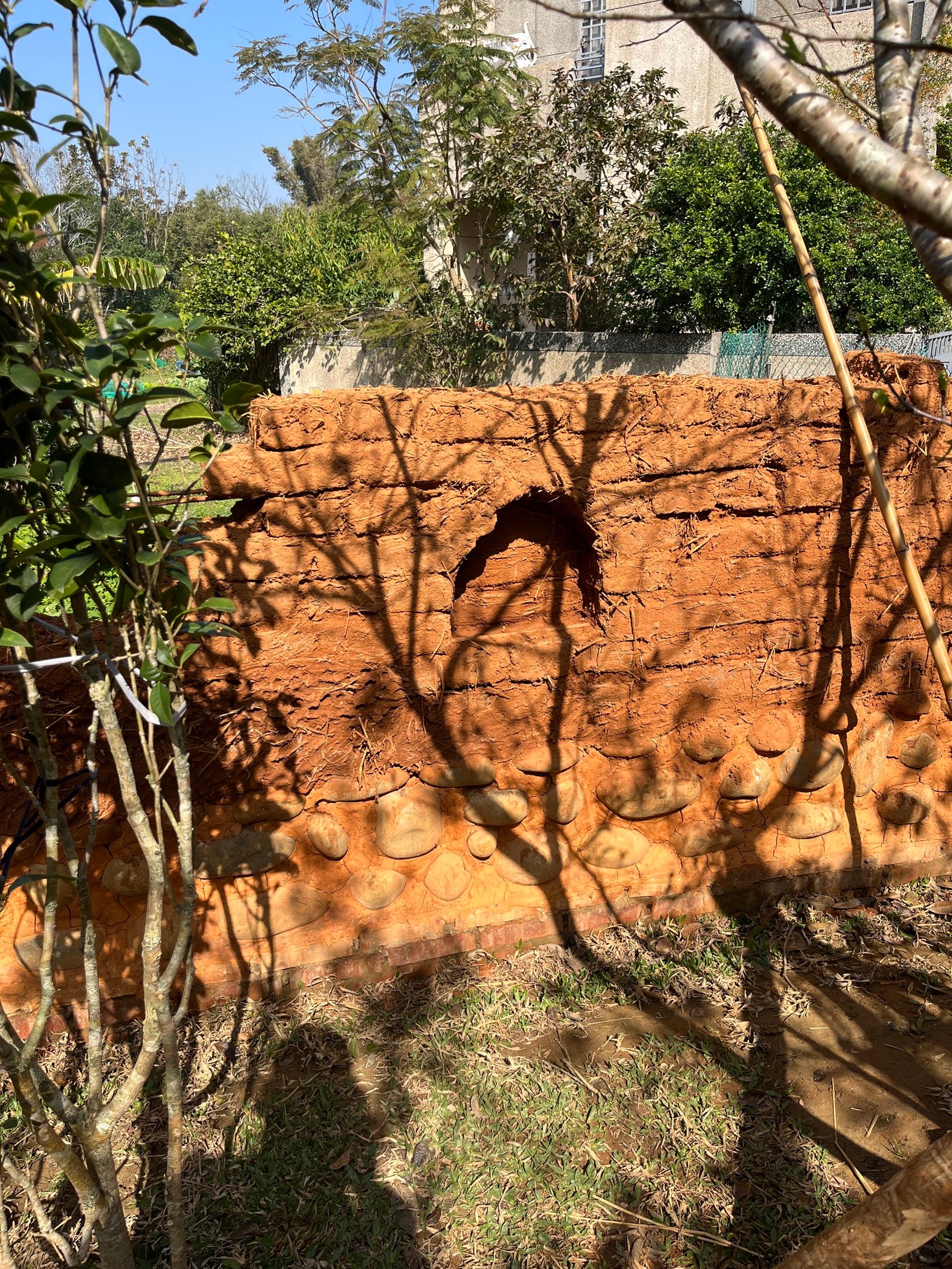 Lehmziegelmauer Detailansicht: Risse und Erosion, roter Lehm mit Strohanteil