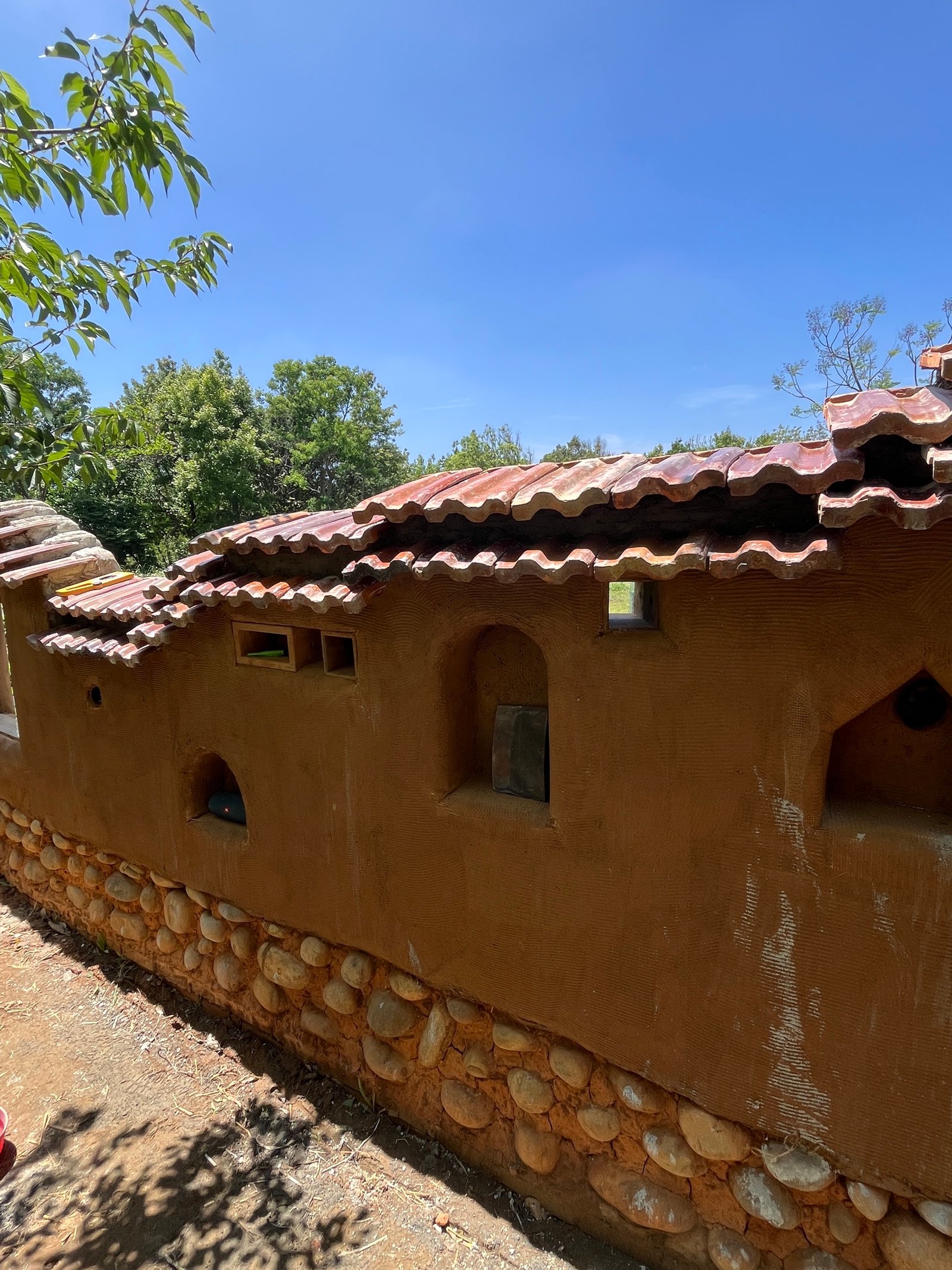 Lehmputzwand mit Dachziegelabdeckung und Flusssteinbesatz, Außenansicht Taiwan